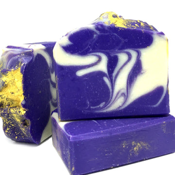 Alchemy soap by Planet Yum is beautiful deep violet with a white swirl through it and topped with golden mica